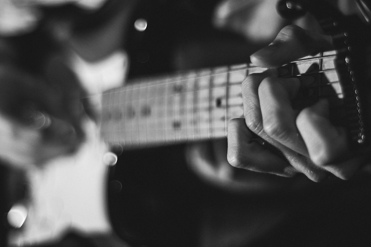 Hand fretting a chord on a guitar neck
