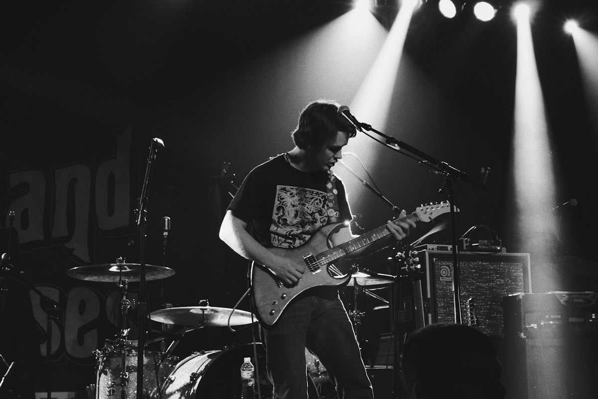 Guitarist performing on stage under spotlights
