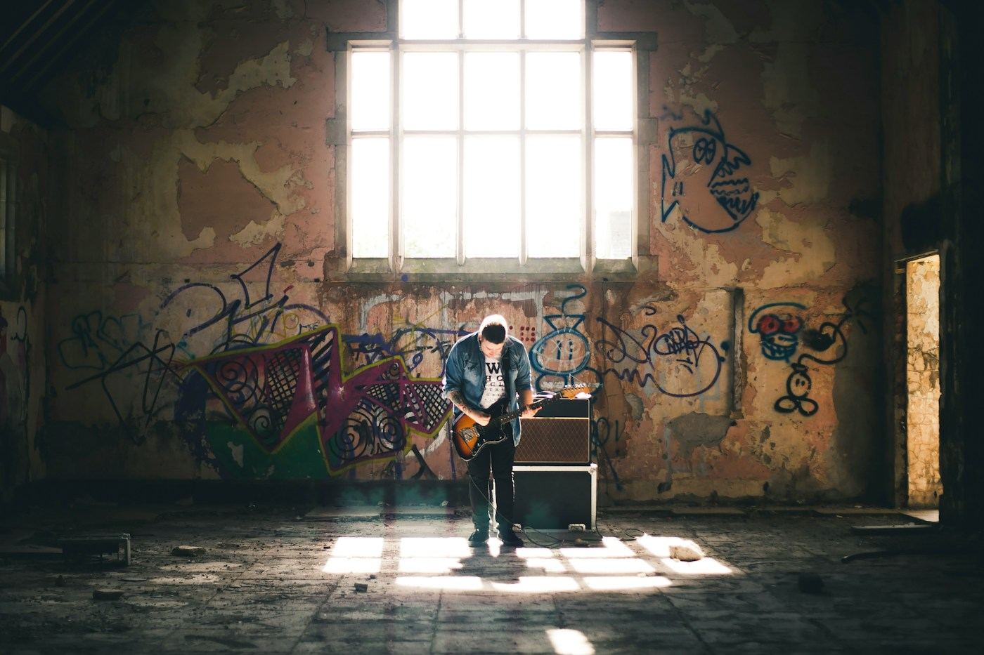 A student playing guitar in a sunlit room